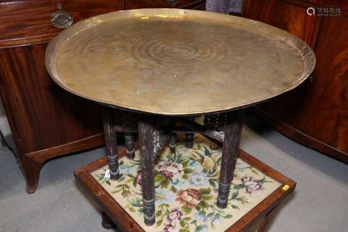 A Middle Eastern circular brass tray top table, on spindle t...