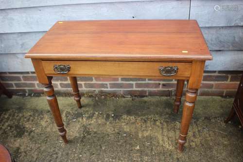 An Edwardian mahogany side table, fitted one drawer, on turn...