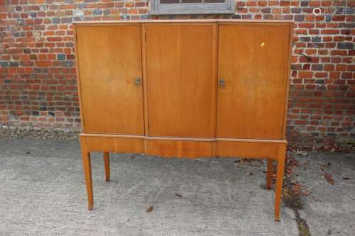 A 1930s walnut side cupboard enclosed three doors, on square...