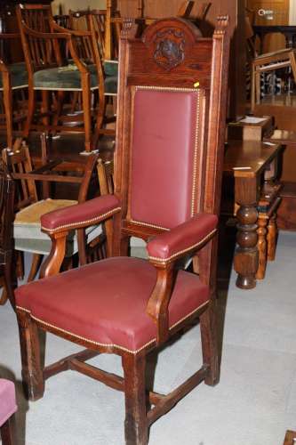 A masters carved oak high back chair, upholstered in a burgu...