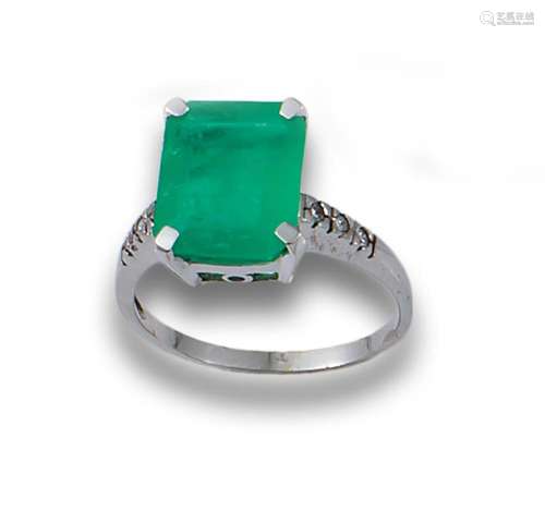 18kt white gold ring with a central emerald cut emerald, wit...