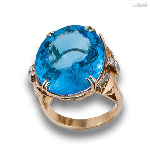 Large 18kt rose gold ring with blue topaz. flanked by brilli...