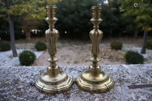 Paire de chandeliers en bronze à patine dorée, base polylobé...