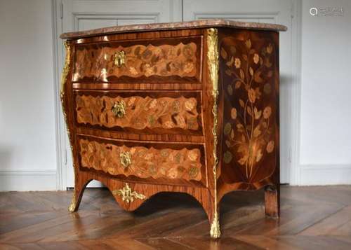 Commode galbée en placage de bois précieux ouvrant par trois...