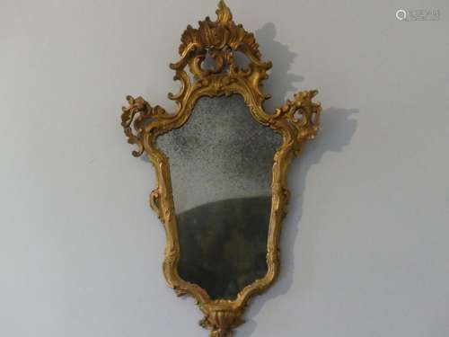 Miroir en bois doré à décor de coquilles ajourées et feuilla...