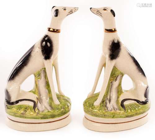 A pair of Staffordshire greyhounds each with a gilt collar a...