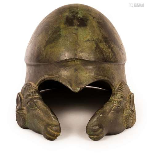 A bronze helmet, after the antique, modelled with cast rams ...