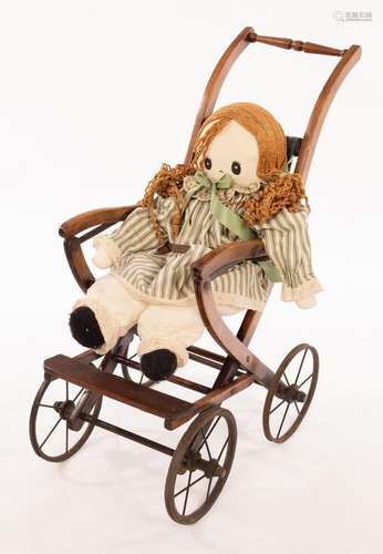 A childs early 20th Century four-wheel pushchair and a rag d...