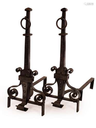 A pair of wrought iron fire dogs with ring handles over scro...