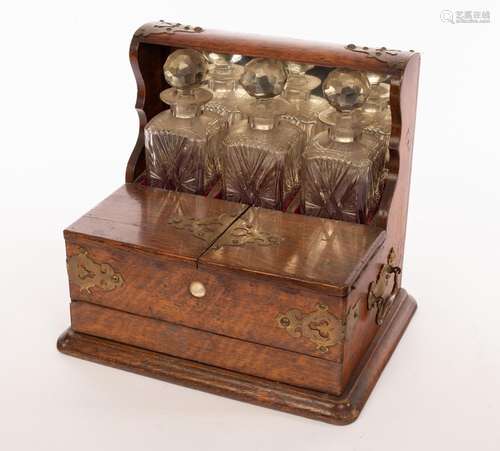 A late 19th Century brass mounted oak tantalus fitted three ...