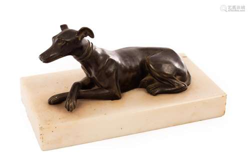 A bronze figure of a recumbent whippet, the white marble pli...