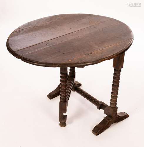 A Charles II oak coaching table, with oval tip-up top on bob...