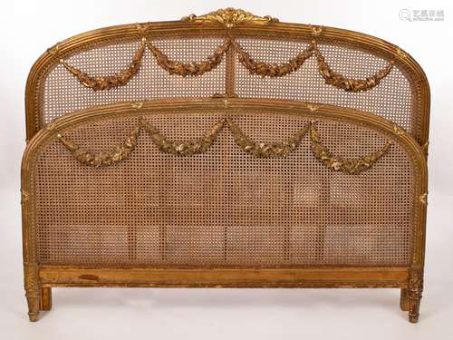 A French late 19th Century caned bed head and foot, each wit...