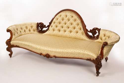 A Victorian sofa with central moulded arch, upholstered back...