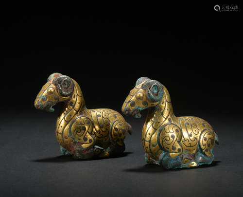 A pair of bronze goat ware with gold and silver