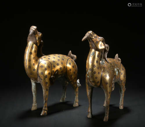 A pair of bronze goat ware with gold and silver