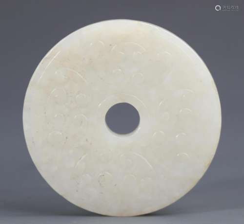 A FINELY CARVED ROUND JADE PENDANT