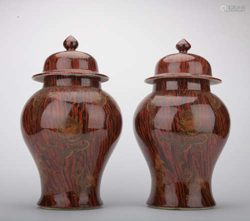 A pair of wooden glazed 'dragon' jar