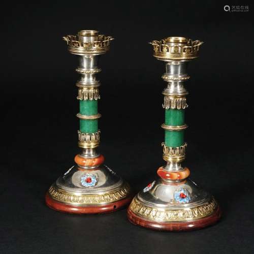 A pair of silver and silver gilt candlesticks decorated with...