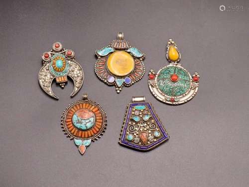 FIVE INDIAN PENDANTS WITH SEMI PRECIOUS STONES ON WHITE META...