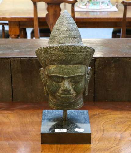 A carved stone head of Buddha, in Khmer Angkor Wat style, th...