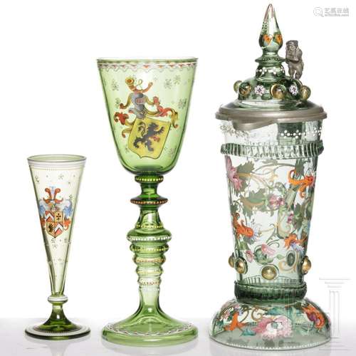 A North Bohemian green glass jug, a flute and a goblet, circ...