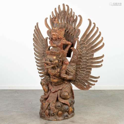 A large wood sculptured statue of a rider on a mythological ...