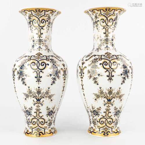 A pair of white porcelain vases with blue and gold decor mar...