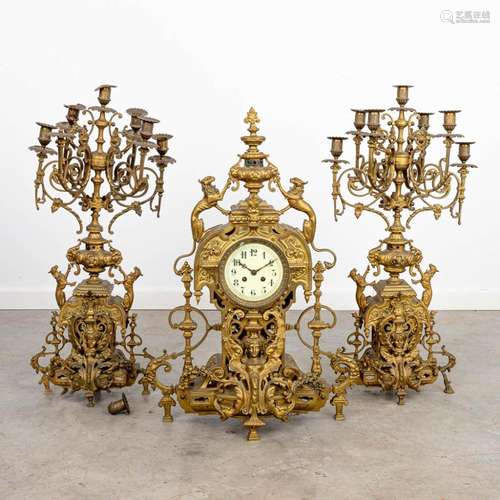 A three-piece mantle clock made of a bronze clock with cande...