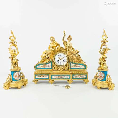 A three-piece garniture clock with candelabra, made of gilt ...