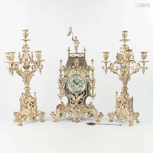 A three-piece garniture clock with candelabra, made of silve...