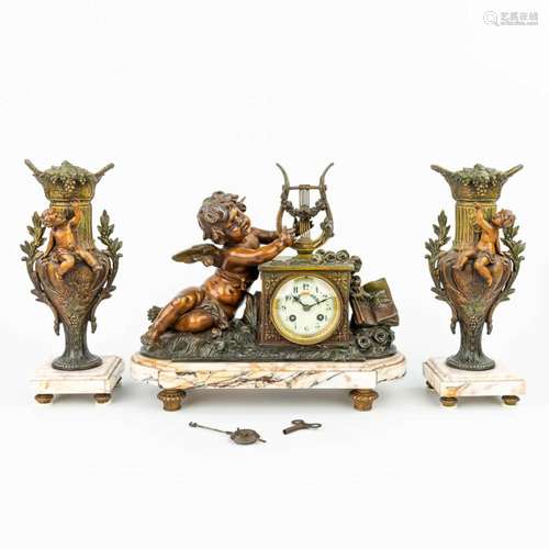 A three-piece mantle clock made of spelter and decorated wit...