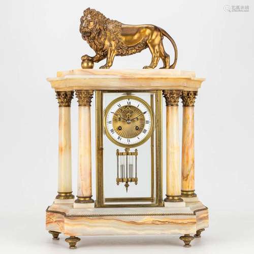 A mantle clock made of alabaster and decorated with a bronze...