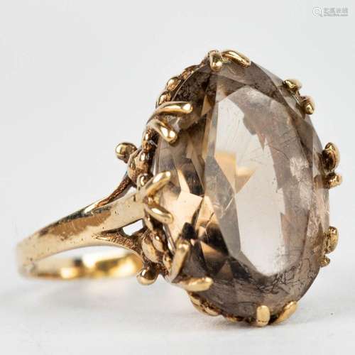 A ring with brown natural stone in a ring made of 9 karat ye...