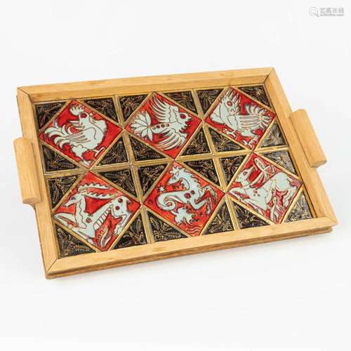 A serving tray made of ceramic tiles with animal figurines a...