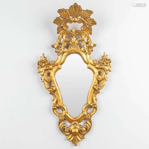 An antique mirror made of sculptured giltwood with stucco. (...