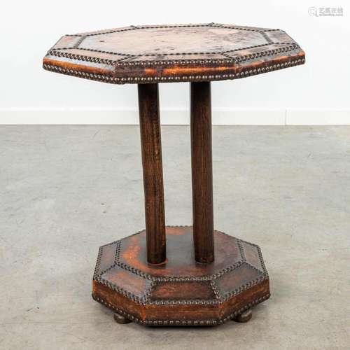 A coffee table made of leather and finished with nails in ar...