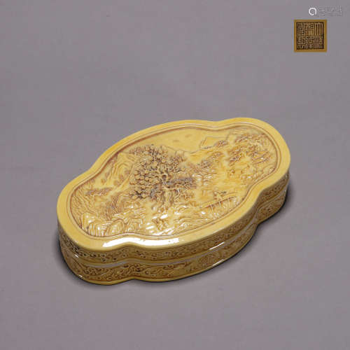 A yellow glazed landscape carved porcelain box