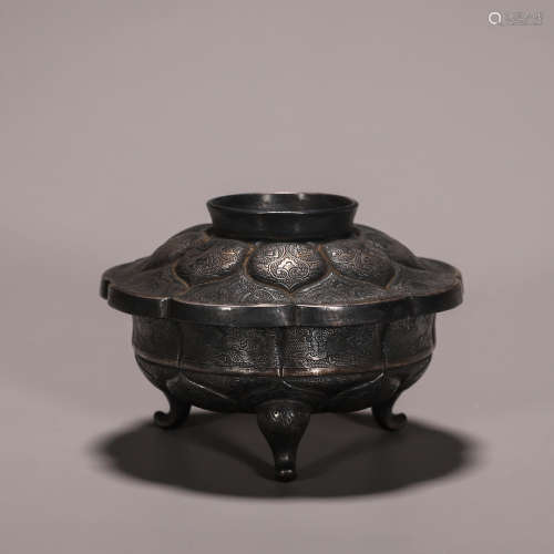 A flower patterned silver covered bowl