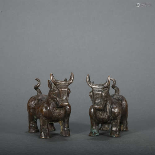 A pair of bronze cow ware with gold and silver