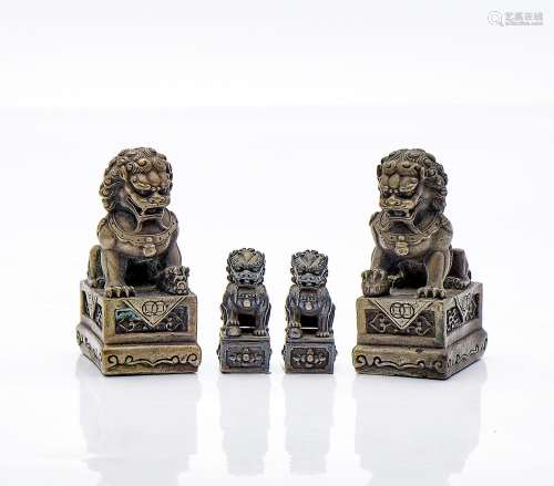 Quatre petites sculptures de lions bouddhistes, en métal arg...