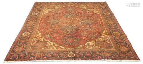 A PERSIAN HERIZ CARPET, hand-knotted, the deep red field wit...