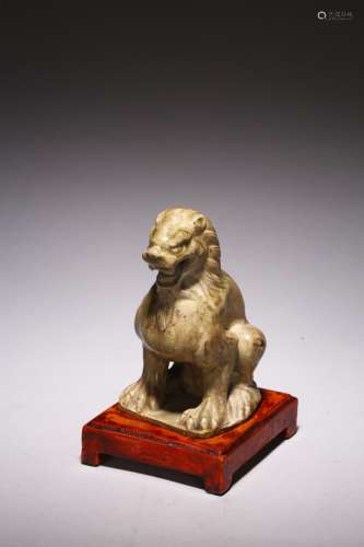 A CELADON POTTERY MODEL OF SEATED LION