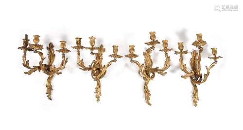 A set of four Louis XV gilt metal three light wall appliques