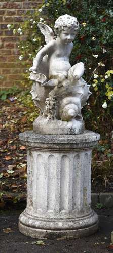 A sculpted marble figure group of a winged putto climbing fr...