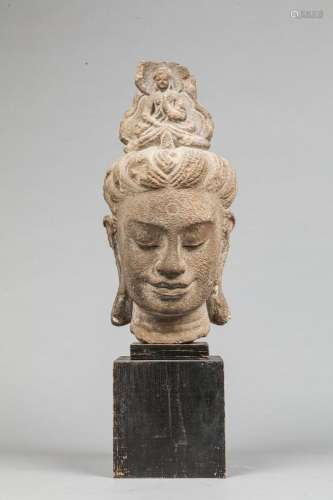 Tête de divinité féminine en pierre taillée
Style Khmer
Socl...