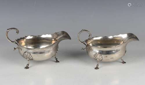A pair of Edwardian silver sauce boats, each with wavy rim a...