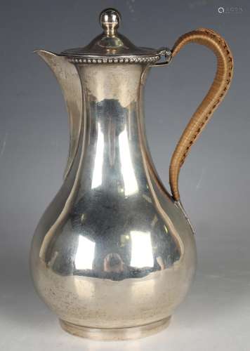 A George III silver hot water pot with flared neck and low-b...