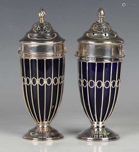 A near pair of silver sugar casters, each pierced cover with...