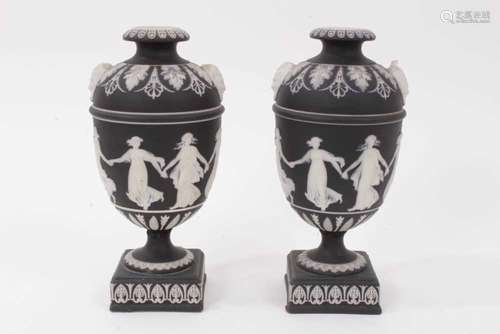 A pair of Wedgwood black Jasperware urns, decorated in relie...